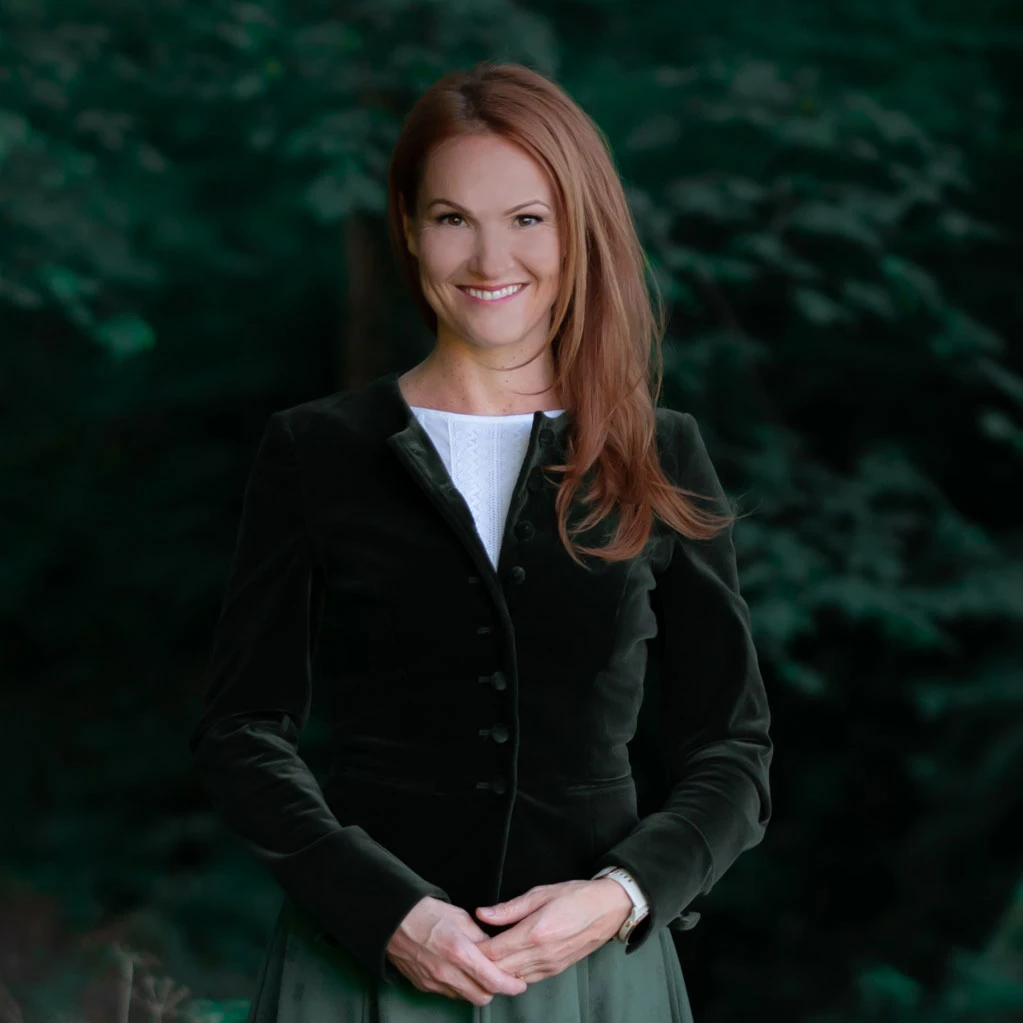 Brigitte Adam im Portrait vor grünem Naturhintergrund - Adam Geschenke Österreich