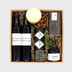 Festliche Geschenkbox von Adam Geschenke mit zwei Flaschen, Waldhonig, Schokolade, Gewürzen, Kürbiskernen und süßen Spezialitäten