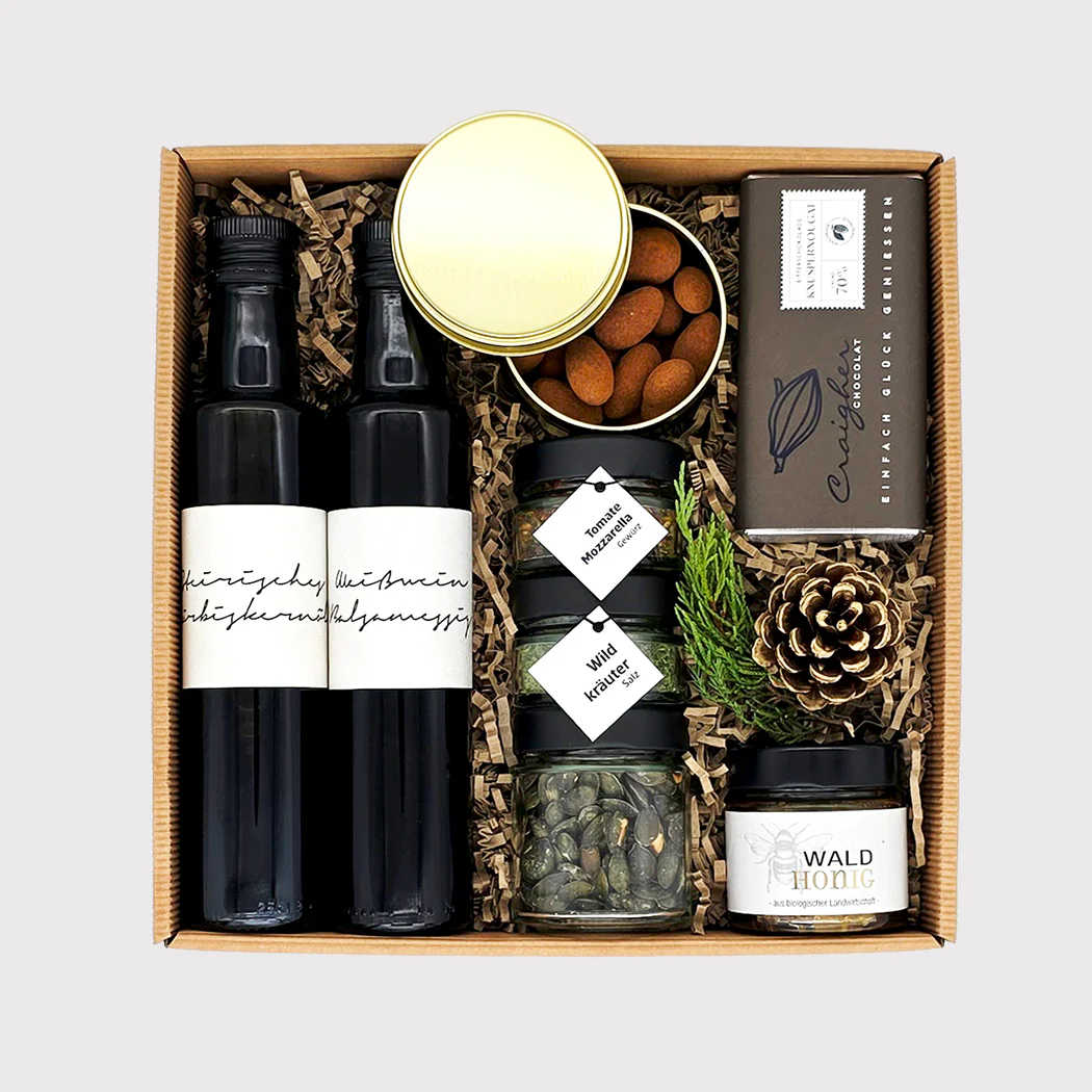 Festliche Geschenkbox von Adam Geschenke mit zwei Flaschen, Mandeln, Kräutern und weiteren Spezialitäten aus der Steiermark in Österreich