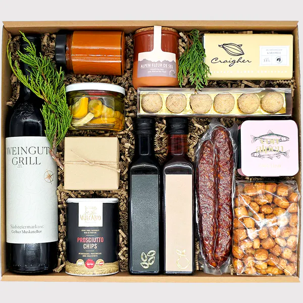 Opulente Geschenkbox von Adam Geschenke mit Wein, Wurstspezialitäten, Schokolade, eingelegtem Gemüse und ausgewählten Feinkostprodukten