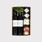 Geschenkbox von Adam Geschenke mit zwei Flaschen, Gewürzen, süßen Spezialitäten und buntem Fruchtkonfekt